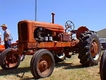 tractor is orange with rounded grill, black badge, narrow front